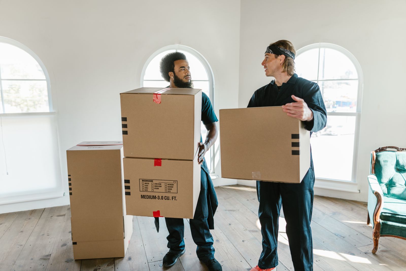 Room on moving day with movers carrying boxes